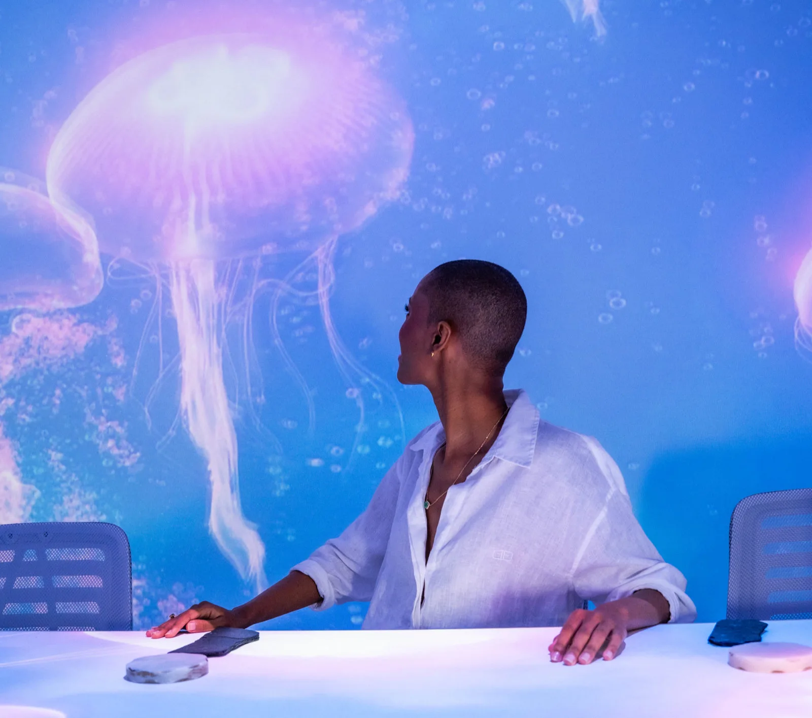 Interacción sensorial con tecnología visual en una cena inmersiva con luces y ambiente digital.